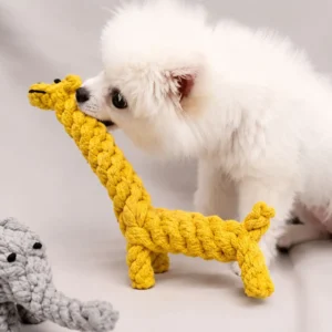 Small white dog chewing a yellow animal shaped cotton rope giraffe dog toy for interactive play and everyday chewing.
