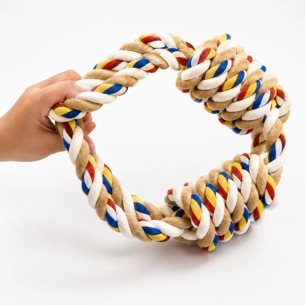 Hand holding a knotted dog rope toy showing the twisted cotton knot detail