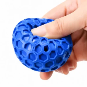 Hand squeezing a flexible blue rubber chew ball to show its soft, bendable texture