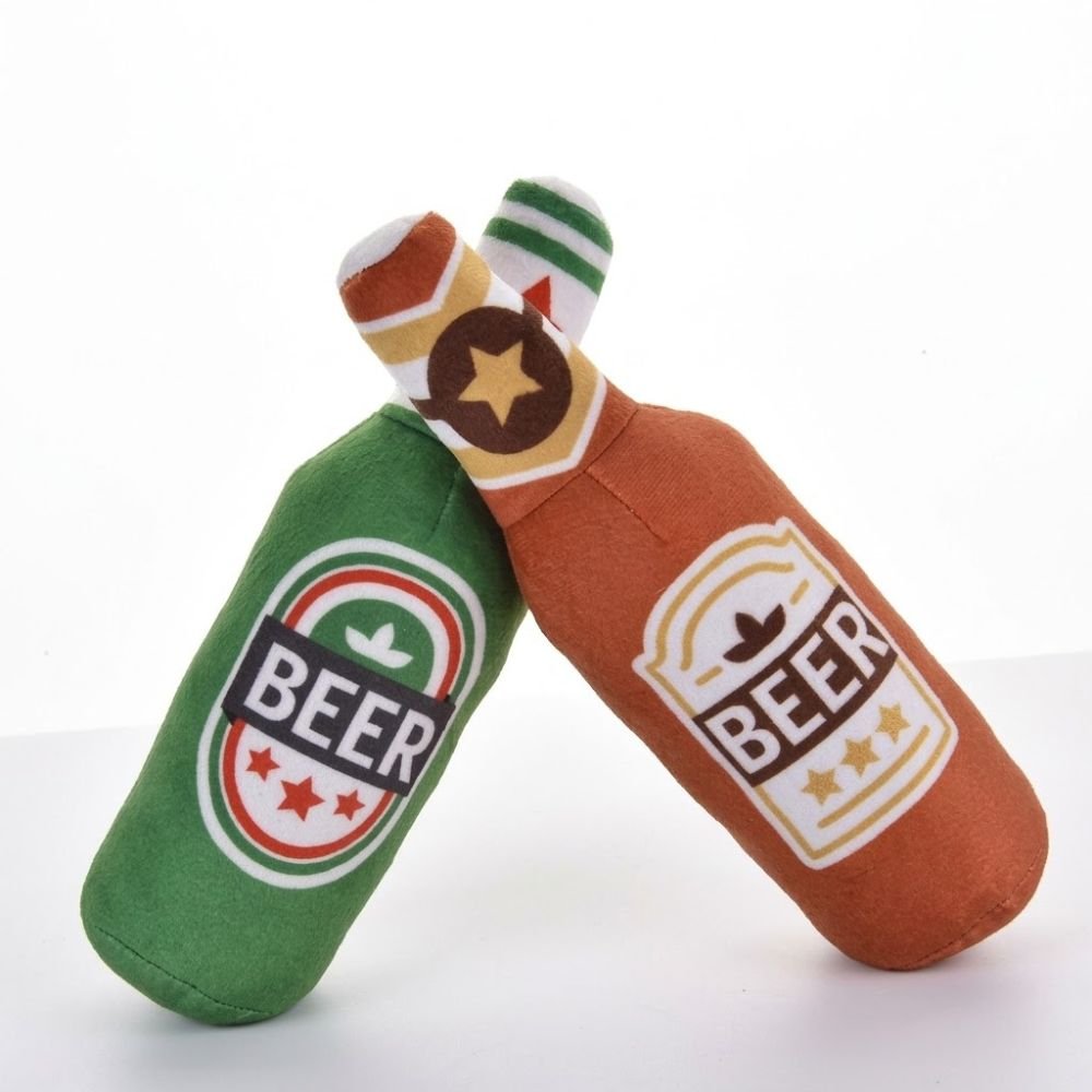 Green and orange beer bottle dog toys leaning together side by side
