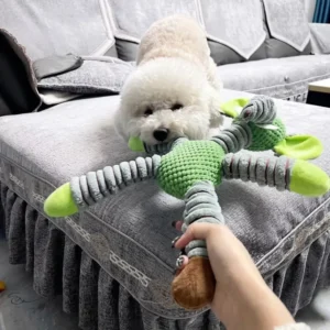 Poodle chewing the green elephant plush animal dog chew toy