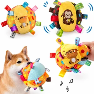 Dog carrying a squeaky plush ball toy by its ribbon tags