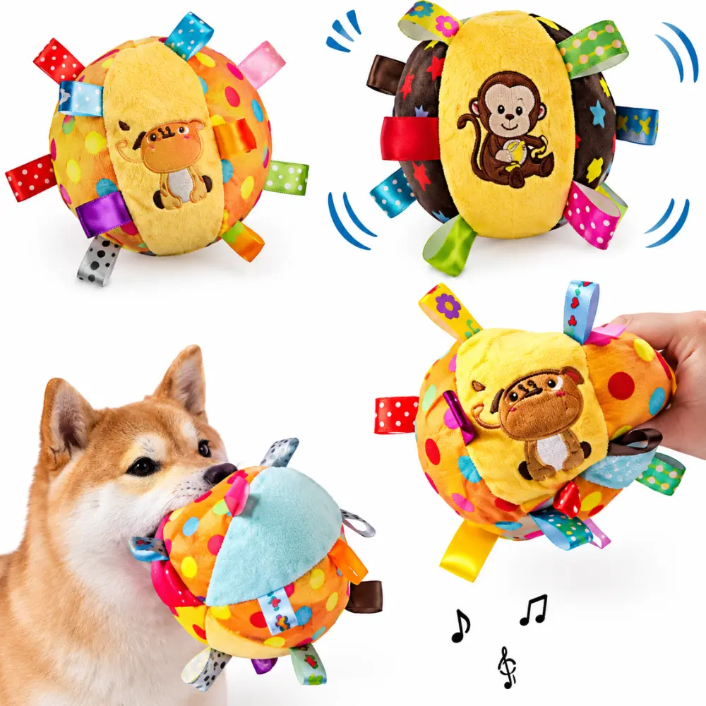 Dog carrying a squeaky plush ball toy by its ribbon tags